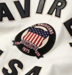 Men’s AVIREX USA white leather varsity bomber jacket with aviator style patches, front zipper, and ribbed cuff details.