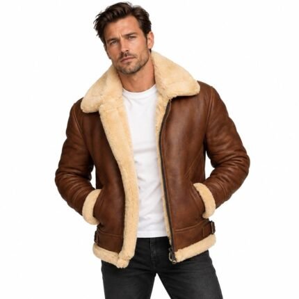Brown shearling leather jacket with a plush cream collar, full lining, zip closure, angled pockets, buckle details, ribbed sleeves and soft trim on a white background.