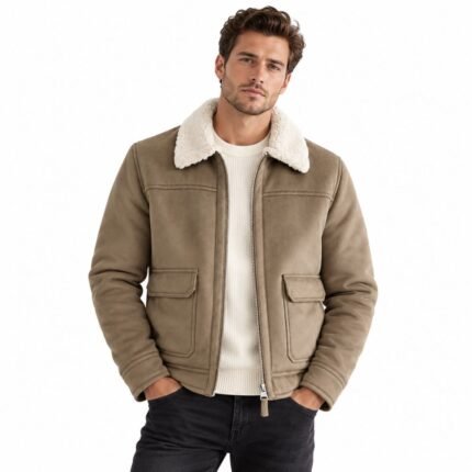 Man wearing the HAVOC brown leather shearling jacket with a cream shearling collar, front zipper, stitched panels, and practical flap pockets against a white background.